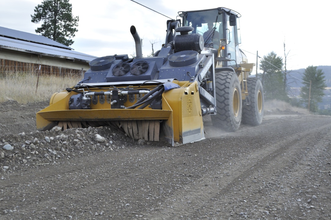 A large machine called a Linear Crusher is taking rocks and dirt and making it into nice looking road gravel.