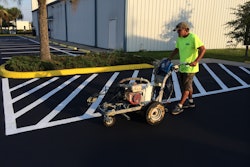 Asphalt Sealers Inc. crew member striping an American Legion Post after sealcoating.