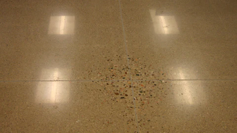 When slabs on ground are polished, non-uniform exposure of aggregate is a result of high spots cause by slab curling. Deflection of many suspended slabs exceeds the upward movement at curled slabs, so polishing may result in even larger areas that exhibit such non-uniform aggregate exposure.