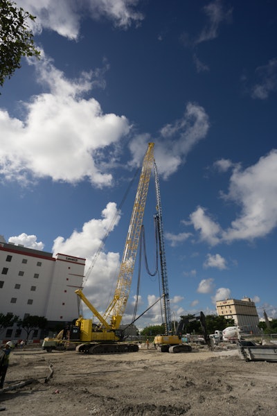 Heavy equipment and workers drill 150 feet deep, sinking first set of piles in phase one of construction for Miami Worldcenter.