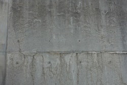 Lines formed by the bubbling and subsequent movement of hydrogen at the interface of new, untreated aluminum forms and concrete prior to initial set are commonly misunderstood as cracks. This wall is more than fifteen years old and exposed throughout its duration with no protective coating. It is a yard wall formed for the sole purpose of pre-treating new aluminum forms, a process they no longer use due to manufacturer pre-treatments.