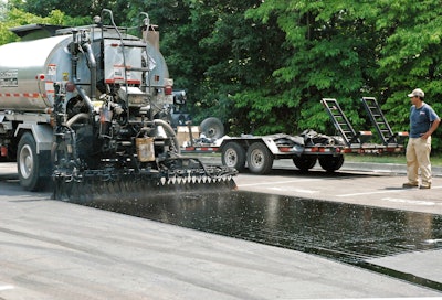Asphalt emulsion bond coat placed full width with overlapping nozzle pattern will result in more durable parking area overlay.