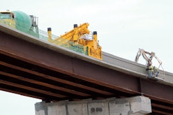 WMC Contracting’s crew slipforms new bridge parapet on a flyover for the Memphis I-40/240 interchange project. They are working 108 feet (33 m) above ground level with their GOMACO 4400 barrier paver.