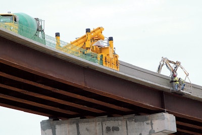 WMC Contracting’s crew slipforms new bridge parapet on a flyover for the Memphis I-40/240 interchange project. They are working 108 feet (33 m) above ground level with their GOMACO 4400 barrier paver.