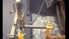 This is the proper amount of mix overlap from lane 2 to lane 1. In this case, the amount of overlap is in the range of 1 to 1-1/2 inches. Given this amount of overlap, no mix has to be moved off of the top of lane 1. No raking of the mix at the longitudinal joint is needed.