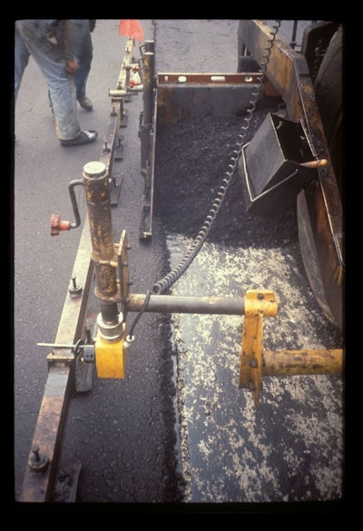 This is the proper amount of mix overlap from lane 2 to lane 1. In this case, the amount of overlap is in the range of 1 to 1-1/2 inches. Given this amount of overlap, no mix has to be moved off of the top of lane 1. No raking of the mix at the longitudinal joint is needed.