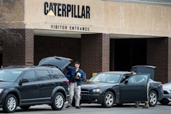 Federal officials gather at their vehicles as they execute a search warrant at the Caterpillar facility in Morton, Ill., one of three Cat facilities they're searching in Central Illinois today.