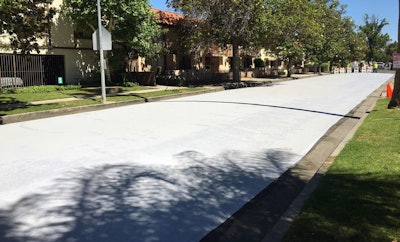 Workers apply a cool pavement coating to a street Saturday May 20, 2017 in Canoga Park. The coating is designed to reduce temperatures on the the surface of streets during Southern California heat waves.
