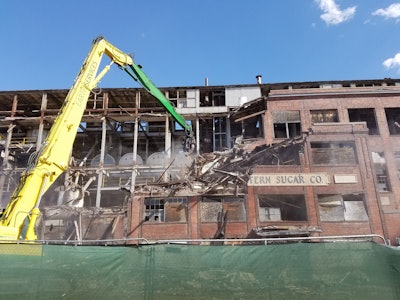 ESA’s strategy included traditional abatement and demolition of the smaller structures first, since they were safe to abate. Once complete, ESA proposed traditional abatement on any easy-to-access sections of the main mill, removing as much bulk asbestos as safely feasible. ESA would then complete structural demolition of the mill, leaving the remaining asbestos in place. Once demolished, all trucks would be lined and wrapped so that the materials could be hauled without emissions.