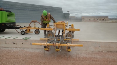A Structural Associates crew member watches closely while operating an E-Z Drill 210-3 SRA slab rider at Westover Air Reserve Base. In all, the contractor drilled 27,000 holes as part of a project to update the base’s aircraft refueling system.