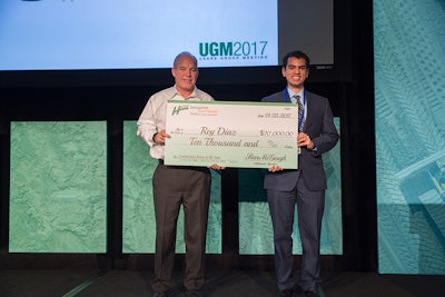Steve McGough, president and COO of HCSS, handing Rey Diaz, 2016 Intern of the Year, the $10,000 scholarship check.