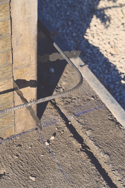 Chalk lines on the footing designate the inner formwork wall line. The width of the footing minus the wall thickness should leave enough footing along the outside to support the wall forms.