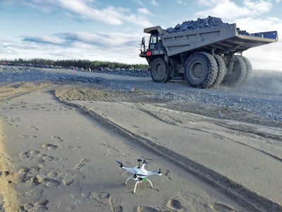 A drones crouches near a haul truck on a Bechtel project. Drones have created a competely new construciton equipment category.