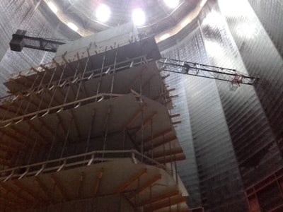 The staircase and elevator shaft erected in the center of the building will function as the tower crane on which a jib would be mounted.