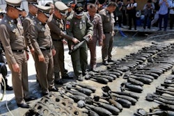 Police offices inspect some of the uncovered practice bombs found at the Bangkok construction site.