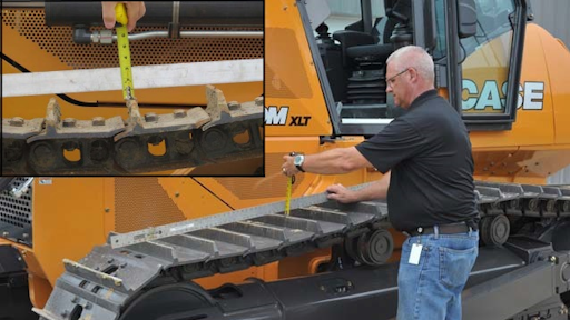 To determine track tension, measure to the grouser tip from a straight edge or string stretched from the carrier roller to the idler or sprocket, whichever sags most. Check the manuals for the machine model at hand for the full procedure and specific sag prescription.