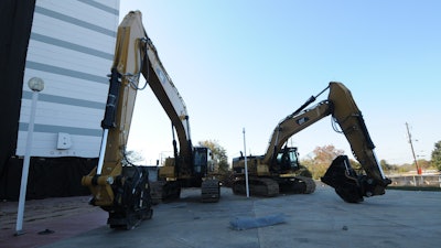 An assortment of tracked excavators with various attachments and other heavy equipment WERE used throughout the demolition process.