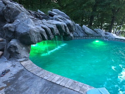 A concrete canopy creates a secluded grotto, complete with a waterfall, at one end of the pool.