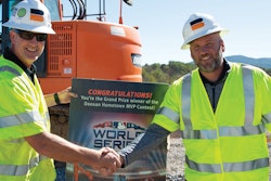 Hometown MVP contest winner Chris Caldwell (left) receives a commemorative ticket from Doosan Infracore North America Director of Marketing Todd Roecker.