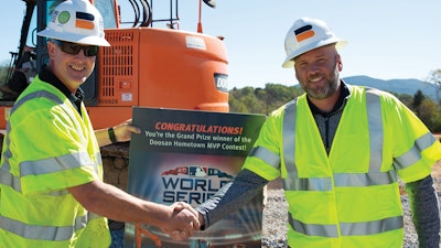 Hometown MVP contest winner Chris Caldwell (left) receives a commemorative ticket from Doosan Infracore North America Director of Marketing Todd Roecker.