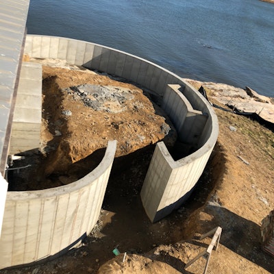 The finished concrete retaining walls ready for stone veneer show the accuracy of the smooth radius created using the steel-ply forming system.
