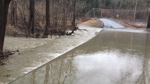 Overflow from the White River runs over a road near the village of Royalton. Roads across Vermont were closed after heavy rain and snowmelt caused flooding.
