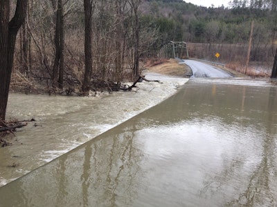 Overflow from the White River runs over a road near the village of Royalton. Roads across Vermont were closed after heavy rain and snowmelt caused flooding.