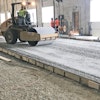 Base course being compacted with vibratory roller.