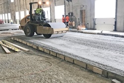 Base course being compacted with vibratory roller.