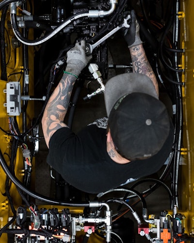 Zach Clark is an assembler with Weiler. He is installing hydraulic lines to the hydraulic pump of a Weiler road widener.