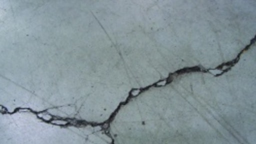 Unrestricted crack width growth leads to spalled edges along out-of-joint cracks when exposed to wheeled traffic.