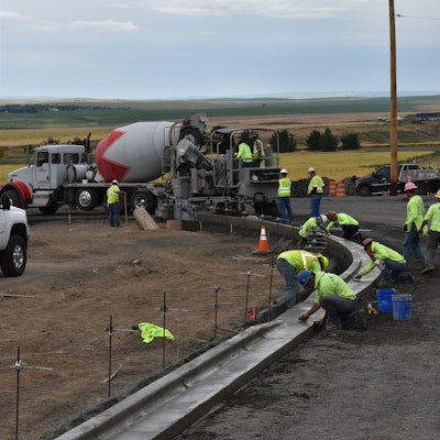 Finishers brush out any minor imperfections left behind by the curb machine.