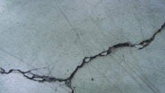 Unrestricted crack width growth leads to spalled edges along out-of-joint cracks when exposed to wheeled traffic.