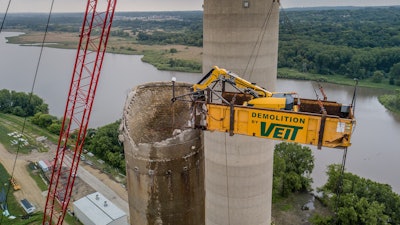 A 450-ton Manitowoc 2250 crane outfitted with a custom box lifts and carries the Brokk 500 during the demolition process.