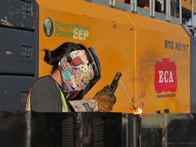 A Burke employee worked behind the piling rig to weld final sheet pile connections.