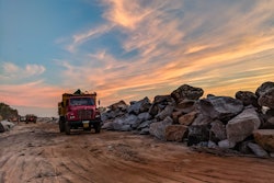 Red Dump Truck Near Filed Rocks Under Cloudy Sky 1044290