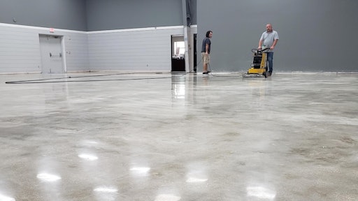 Pastor Josh Moore assists Roy Mathis of GranQuartz during the polishing process.