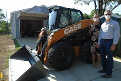 Ann Fox with Habitat and Troy Williams with CASE alongside the donated skid steer