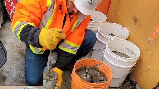 Rodding on the top layer of a concrete cylinder.