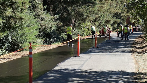 Crews work to sealcoat a road at the University of California/Davis.