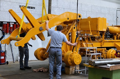 Wheel loader experts at work: The restored lift arm is mounted in the repair center.