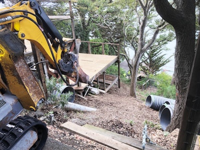 Working in tandem with a 25-ton tow truck parked on the road, Jamba maneuvered the Brokk machine down the hillside.