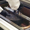 Researcher prepares asphalt specimen for the DCT (Disc Shaped Compact Tension) test.