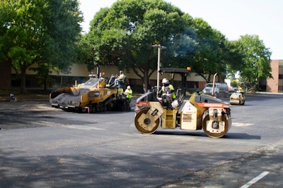 At the job site, the E&B Paving crew pours and rolls the RAP and Invigorate rejuvenator mixture, creating a smooth surface for the parking lot.
