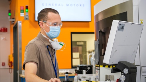 Manufacturing engineer Benjamin LeBlanc inspects a 3D printer at the GM Additive Industrialization Center in Warren, Michigan.