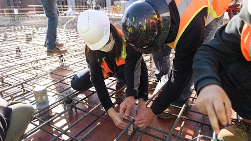 Civil engineering professor Luna Lu (left) helps install a sensor that her lab developed into the third floor of what will be a Purdue building complex.