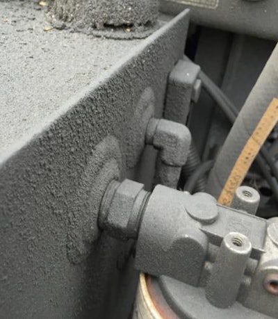 Hydraulic tank that has been covered with dirt and oil from a leak. The cap on the hydraulic tank is vented, and if the debris gets into the tank the oil will be contaminated.