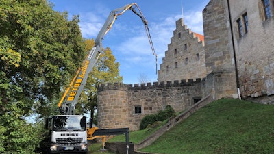 In action with ease: The Liebherr 42 M5 XXT truck-mounted concrete pump with the innovative XXT outrigger system masters the tight space conditions in front of the historic castle.