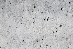 Coating voids and pores in a concrete floor.