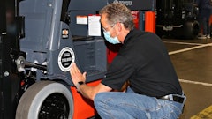 Toyota associate applies commemorative placard, completing the assembly of the milestone 750,000 forklift to roll off Toyota Material Handling's production line in Columbus, Indiana.